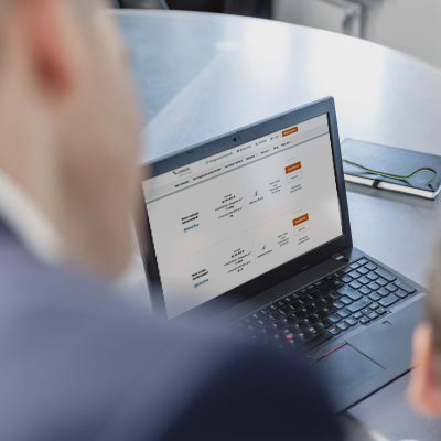 Im Bild ein Laptop mit einem Screenbild aus der Webseite v-check.de, das zwei Strategien der PROAKTIVA.digital zeigt. Der Rest ist Unschärfe.