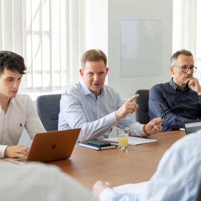 Mehrere Vermögenspartner in Diskussion an einem großen Konferenztisch