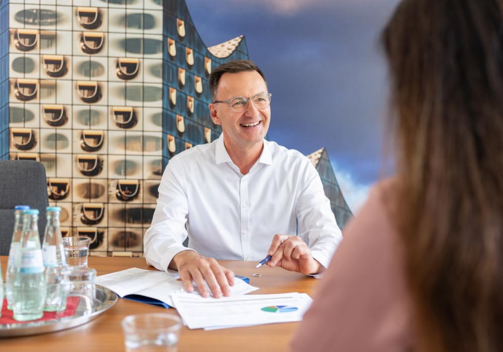 Vermögenspartner Andreas Vulovic mit Unterlagen im Gespräch mit einer Kundin